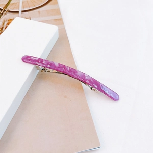 Detail of elegant purple marble acetate hair clip with golden metal spring fastener