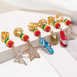 Macro view of gold dreadlock jewelry with Rasta beads and rhinestone star pendants
