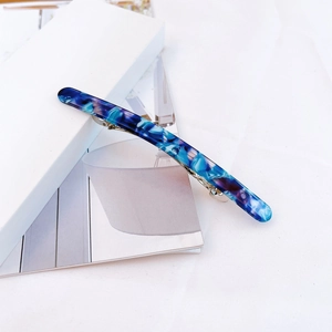 Detail view of long acetate hair clip with blue and purple marble texture and metal spring