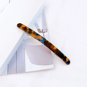 Close-up of a tortoiseshell acetate hair clip with a sturdy silver metal spring clip