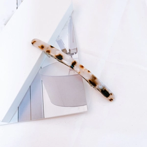 Close-up of tortoiseshell acetate hair clip with silver spring metal fastener