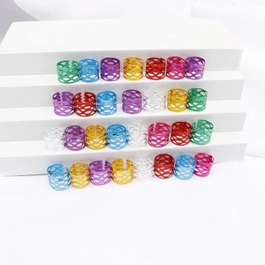 Detalle de anillos metálicos huecos de colores para decorar rastas y trenzas