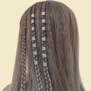 Detalle de cuentas de dreadlocks de malla plateada en extensiones de cabello trenzado