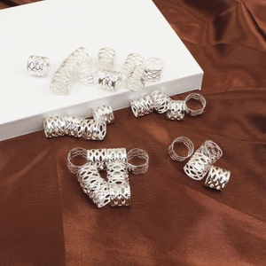 Detalle macro de puños plateados de malla hueca para rastas y anillos de metal para cabello