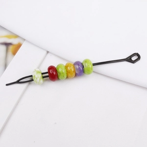 Detail of black metal hair pin with six colorful acrylic beads for dreadlocks