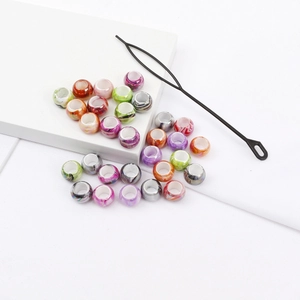 Close-up of colorful large hole acrylic beads with marble texture and threading tool