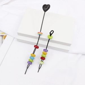 Detail of colorful resin dreadlock beads with rainbow colors and black stick fasteners