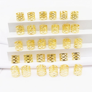 Detalle de anillos de metal dorado calados para trenzas y accesorios de cabello