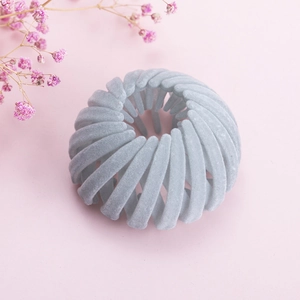 Détail de la pince à cheveux grise velours en nid d'oiseau avec structure extensible