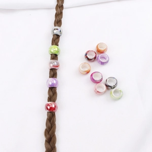Macro shot of colorful marbled hair beads on braids and loose resin decorative rings