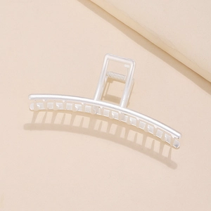 Minimalist matte silver metal hair claw clip with long teeth on a beige background
