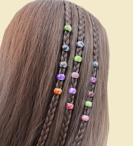 Colorful patterned hair beads for dreadlocks shown on braided hair in various vibrant shades