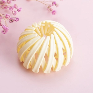 Détail de la pince à cheveux extensible crème montrant la structure en résine