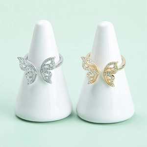 Elegant gold and silver butterfly open rings with crystal pavé on white ceramic stands