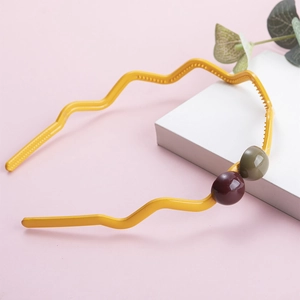 Detail showing wavy yellow headband with contrast beads and non-slip inner teeth