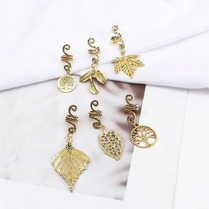 Detailed close-up of 6-piece golden alloy hair charms with tree of life and leaf pendants