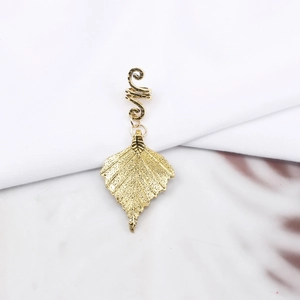 Macro shot of gold leaf dreadlock charms with spiral coil for hip hop braided hair
