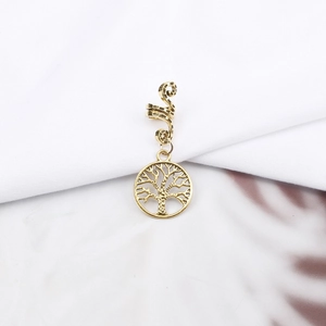 Detail shot of golden spiral hair coil with Tree of Life pendant for braids and dreadlocks