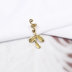 Detail of vintage gold spiral hair rings with leaf pendants for bohemian braids and dreadlocks