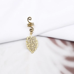 Detail shot of a golden spiral dreadlock hair clip with a vintage leaf pendant