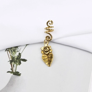 Macro shot of vintage gold alloy spiral hair ring with rose petal and leaf pendant detail