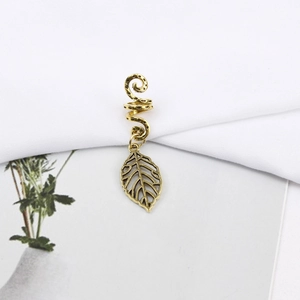 Detailed macro view of vintage gold spiral hair ring with hollow leaf pendant decoration