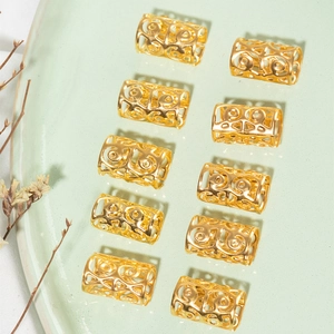Detailed view of hollow golden metal hair cuffs with floral carvings for braids and dreadlocks