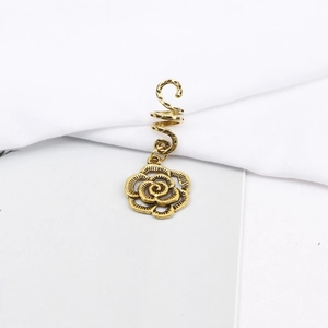 Detail of vintage gold spiral hair rings with a rose pendant for dreadlock styling
