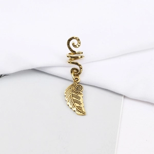 Detailed macro view of vintage gold spiral hair ring with detailed leaf pendant detail