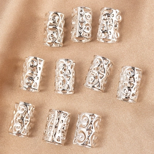 Detail of 10 silver hollow filigree hair rings with vintage embossed patterns on satin