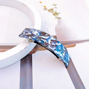 Vue détaillée de la barrette en acétate avec texture marbrée bleue et blanche et clip métal