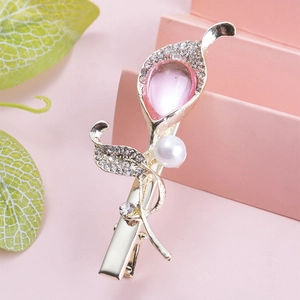 Detailed close-up of a flower hair clip with pink crystal, pearl and gold alloy base