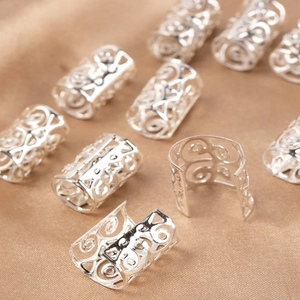 Close-up of silver hollowed hair rings with intricate carved patterns for dreadlocks