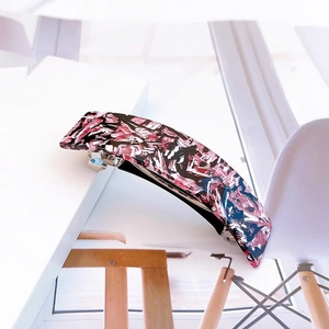 Détail de la pince à cheveux élégante en acétate avec motif marbré rose et noir