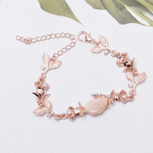 Macro detail of rose gold floral bracelet with cat-eye stones and sparkling crystals