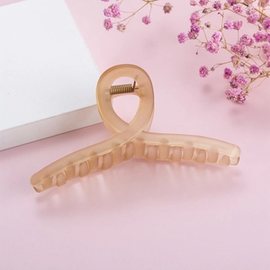 Close-up of a matte pink large hair claw clip with a sleek twisted resin design