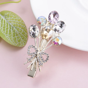 Detailed macro view of a floral crystal hair clip with sparkling rhinestones and ribbon bow