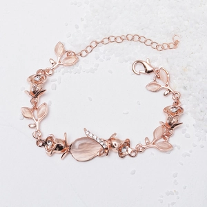 Detailed view of rose gold floral bracelet with pink cat eye stone and lobster clasp