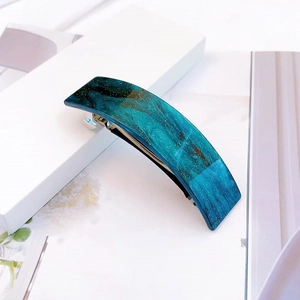 Détail de la barrette en acétate marbré bleu avec paillettes étoilées et fermoir métal