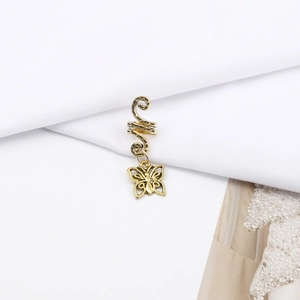 Macro view of vintage gold spiral hair coil with a hollow butterfly pendant charm