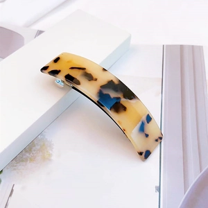 Gros plan sur une barrette en acétate écaille de tortue élégante avec motifs ambrés