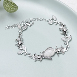 Detail of rose gold flower bracelet with opal stone and crystals on blue tray