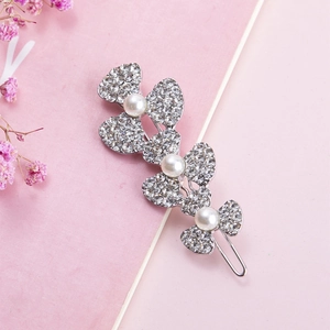 Sparkling rhinestone flower hair clip with pearls on a pink textured background