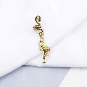 Detailed macro view of vintage gold spiral hair coil with a flamingo pendant charm