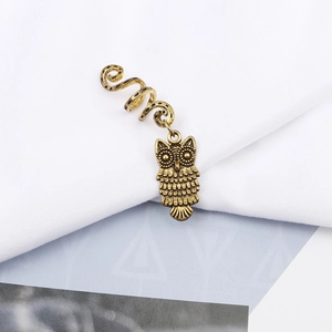 Detailed macro of vintage bronze owl pendant with spiral clip for dreadlock braids