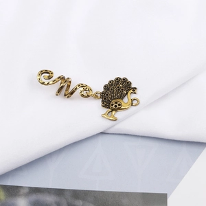 Macro view of vintage gold spiral hair rings featuring detailed peacock pendants for braids
