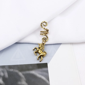 Macro shot of vintage bronze alloy dreadlock cuff with detailed unicorn charm on white fabric