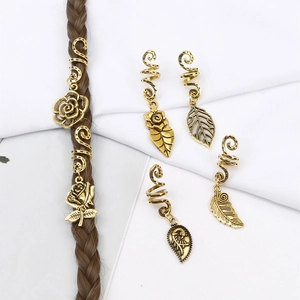 Detailed view of vintage gold spiral hair rings with rose and feather leaf pendants