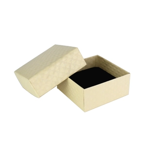 Macro detail of beige cardboard jewelry gift box with textured diamond pattern finish