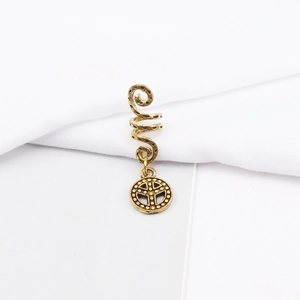 Macro detail of alloy spiral hair coil with bohemian style geometric pendant